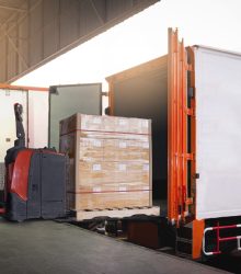 electric-forklift-loading-package-boxes-into-container-trucks-parked-loading-dock-warehouse